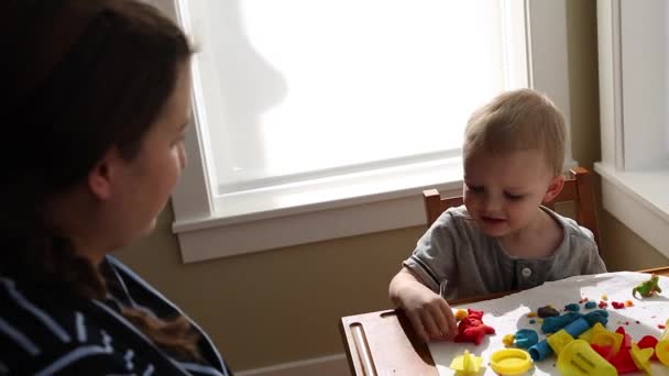 Мальчик и мать играют с тестом — стоковое видео
