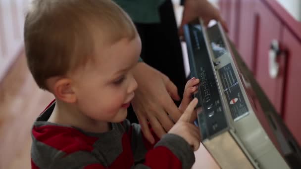 Chlapec pomáhá matce start myčka — Stock video