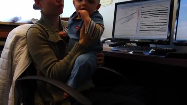 Mujer trabajando en una oficina con el bebé — Vídeo de stock