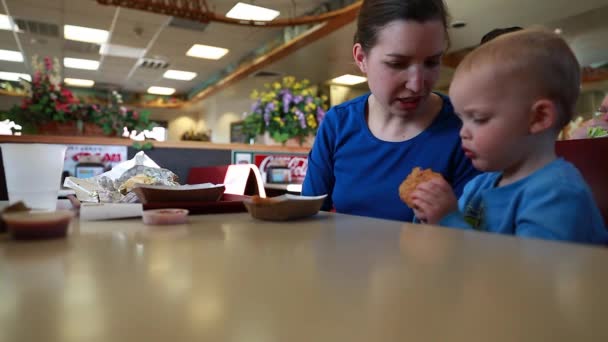 Jongen eten van kip stroken met moeder — Stockvideo