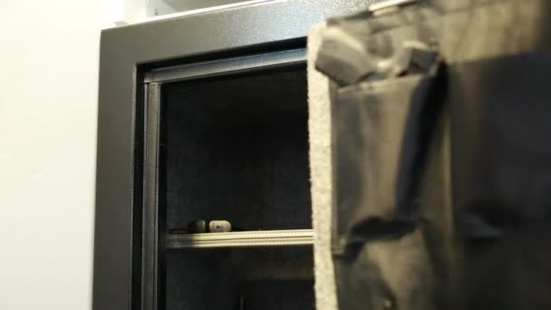 Мужчина вытаскивает пистолет из сейфа — стоковое видео