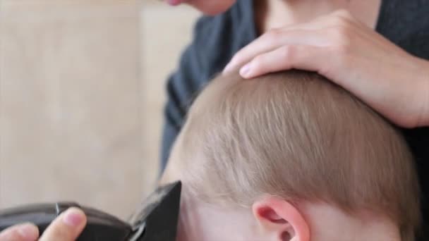 La mujer corta el pelo de un niño — Vídeos de Stock