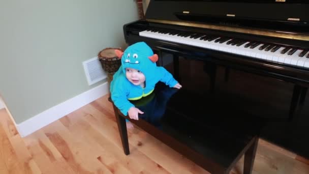 Toddler in costume climbing on piano — Stock Video