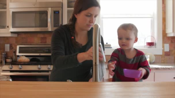 Bambino aiuta la madre a pulire i piatti — Video Stock