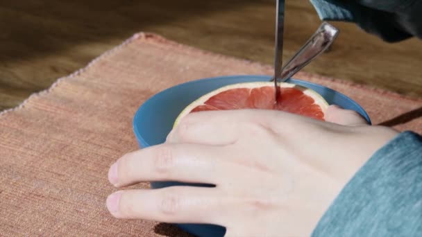Frau schneidet eine Grapefruit — Stockvideo