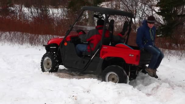 Een man stations vier wheeler in de sneeuw — Stockvideo