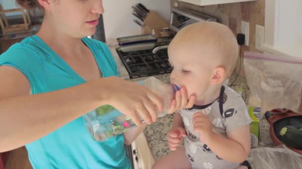 Une mère donnant de l'eau au bébé — Video