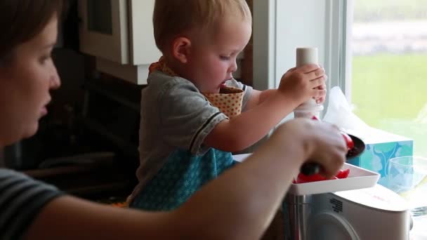 Ett litet barn och mor juice tomater — Stockvideo