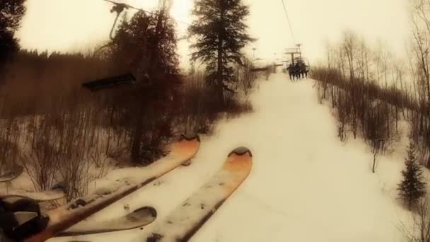 Skiers at a mountain resort on chair lift — Stock Video