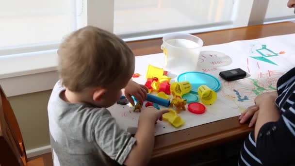 Mutter und Kleinkind lagen mit Spielteig — Stockvideo