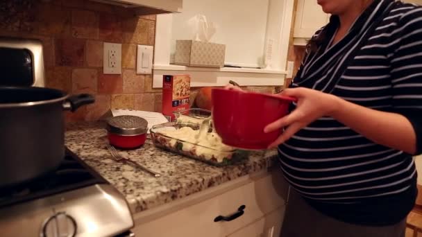 Een zwangere vrouw maakt een braadpan — Stockvideo