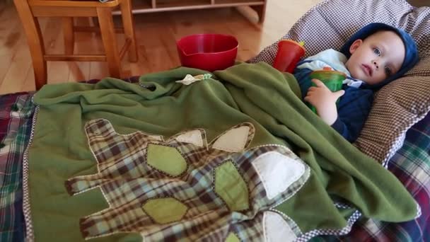 Junge mit Grippe auf dem Boden liegend — Stockvideo
