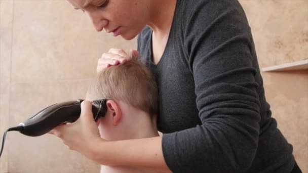 Kvinnan klipper håret på ett litet barn — Stockvideo