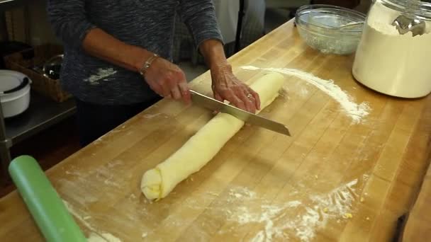 Woman cutting orange roll dough — Stockvideo