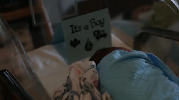 Mujer duerme en una cama de hospital cerca del recién nacido — Vídeo de stock