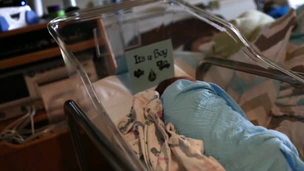 Жінка спить в лікарняному ліжку біля новонародженого — стокове відео