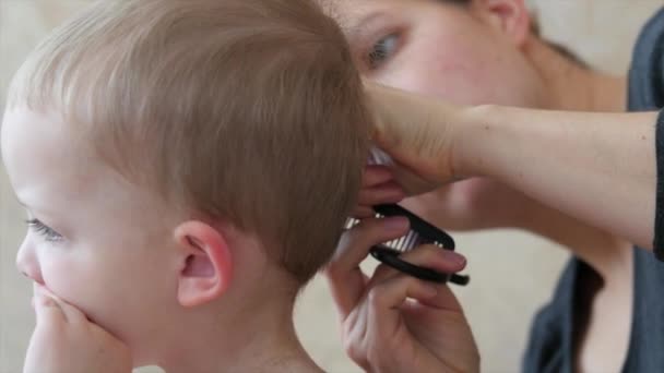Frau schneidet einem Kleinkind die Haare — Stockvideo