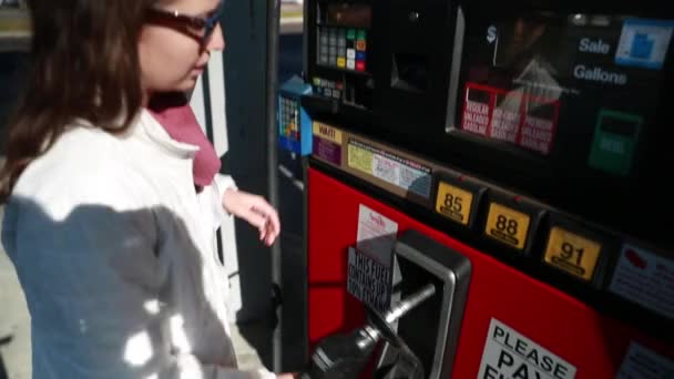 Женщина закачивает газ в машину — стоковое видео