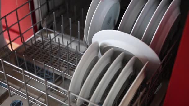 Mulher descarrega a máquina de lavar louça — Vídeo de Stock