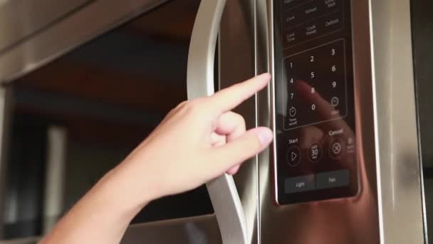 Woman pushing buttons on the microwave — Stock Video