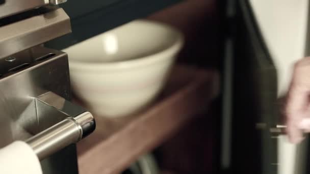 A woman grabs bowl from a cabinet — Stock Video