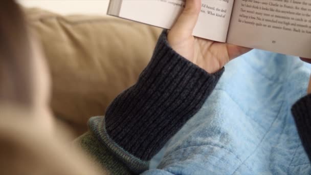 Femme lit livre sur canapé — Video