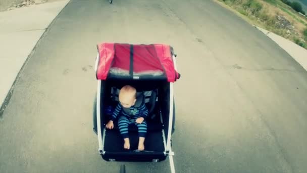 Um menino andando em um trailer de bicicleta — Vídeo de Stock