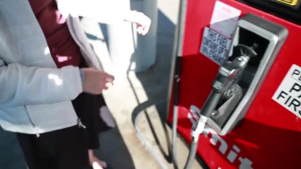 Kvinnan pumpar gas in i bilen — Stockvideo