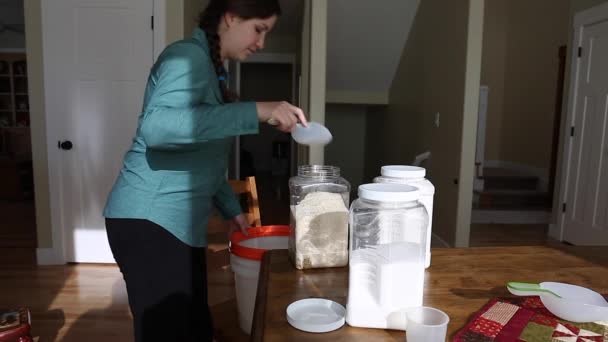 Uma mulher enchendo um recipiente de comida — Vídeo de Stock