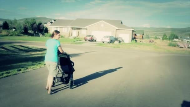 Frau schubst Kleinkind in Kinderwagen — Stockvideo