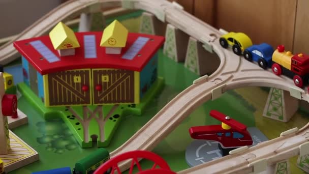 Мальчик играет с игрушечными поездами и автомобилями на треке — стоковое видео