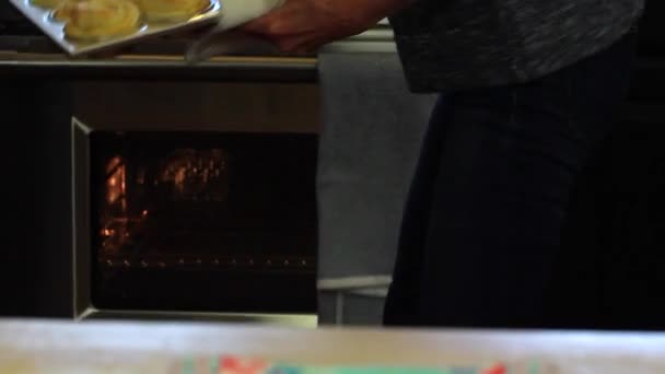 Женщина достает рулоны из духовки — стоковое видео