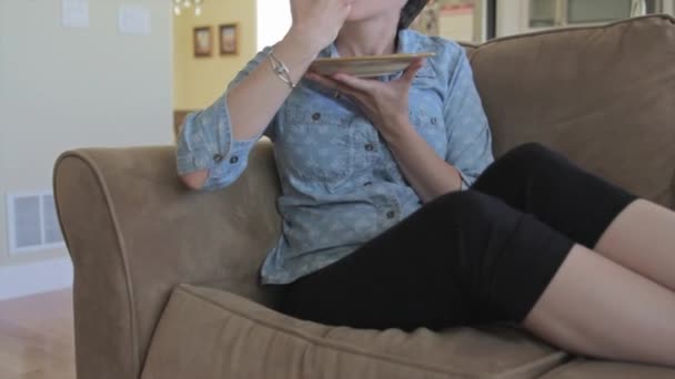 Seorang wanita makan di sofa — Stok Video