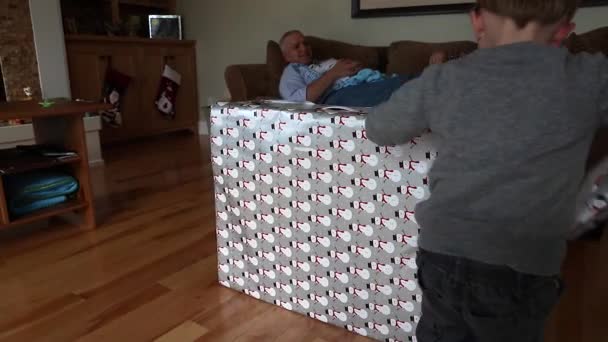 Мальчик разворачивает рождественский подарок — стоковое видео