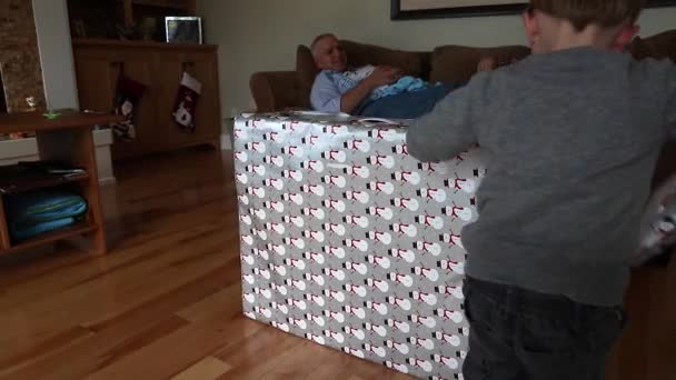 Un niño desenvolviendo un regalo de Navidad — Vídeo de stock