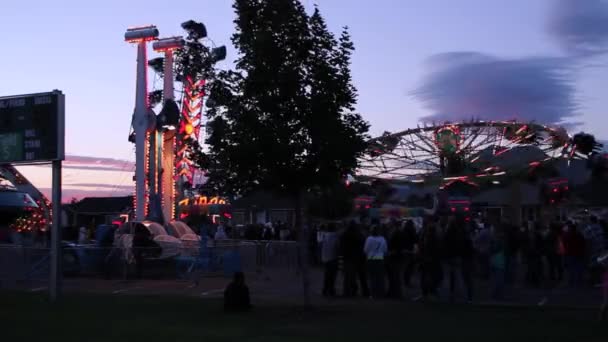 Paseos de carnaval en un parque de atracciones — Vídeos de Stock
