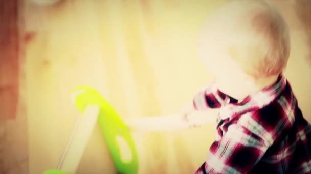 Мальчик играет со своей толкающей игрушкой — стоковое видео