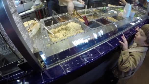 Boy watching workers prepare food — Stock Video