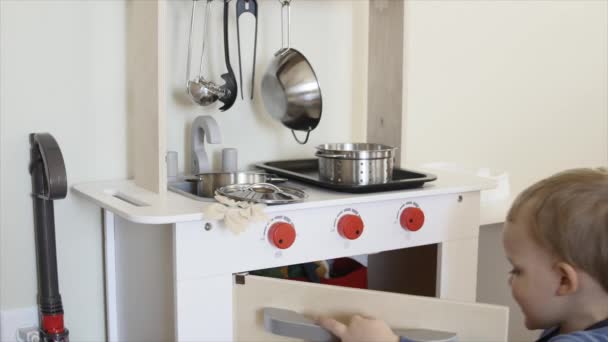 Ragazzo che gioca con un set da cucina giocattolo — Video Stock