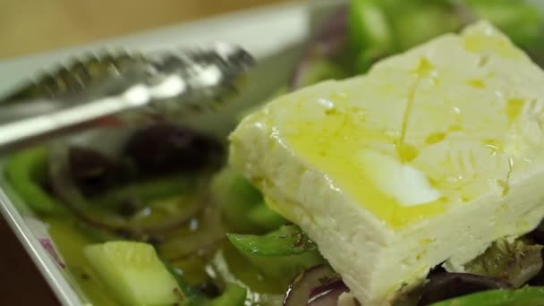 Uma mulher prepara uma salada grega — Vídeo de Stock