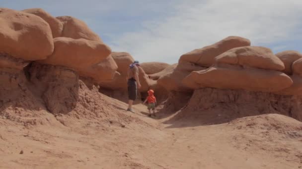 Family hiking through goblin valley — Stock Video