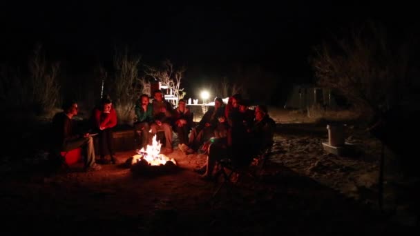 Gezinnen zitten rond een kampvuur — Stockvideo