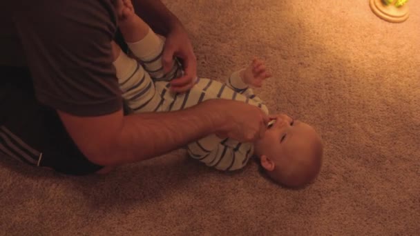 Un padre limpiando los dientes de su bebé — Vídeo de stock