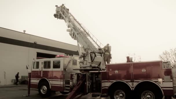 Firefighters on firetruck ladder — Stock Video