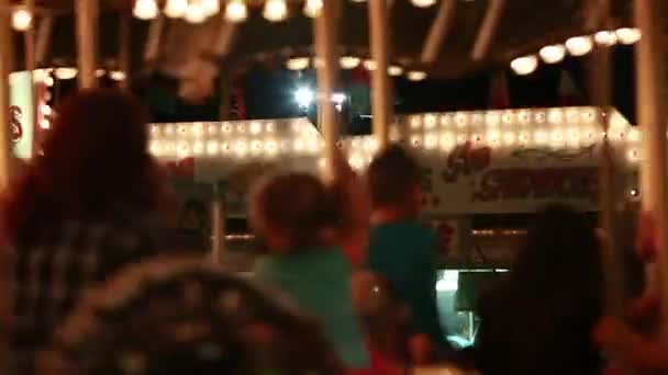 Mensen rijden carnaval carrousel — Stockvideo