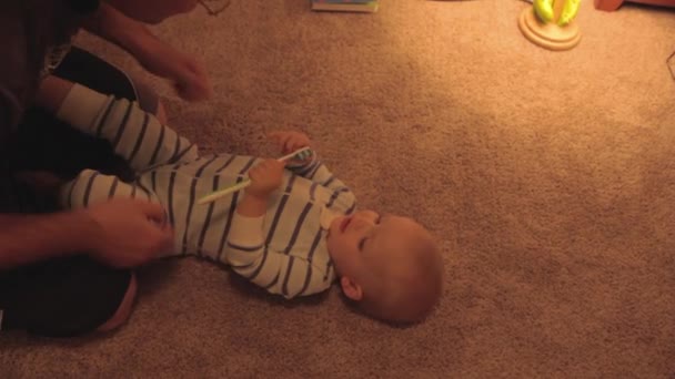 Ein Vater kitzelt seinen kleinen Jungen — Stockvideo