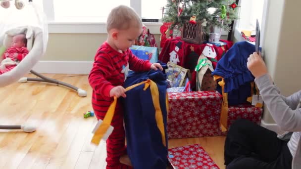 Menino olhando para seus presentes de Natal — Vídeo de Stock