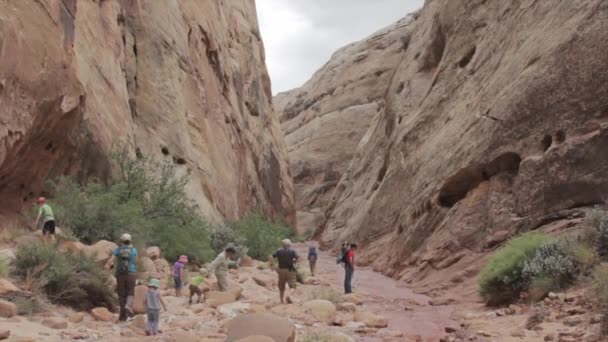 Family hiking through a canyon — Stock Video