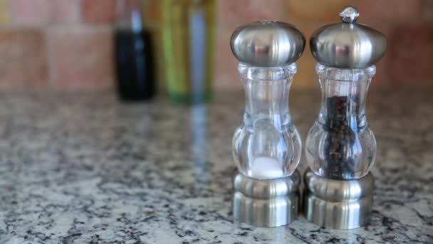 Hand grabs the salt and pepper shakers — Stock Video