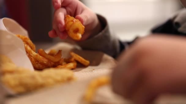 Niño comiendo papas fritas rizadas — Vídeos de Stock